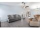 Spacious living room with gray sofa and recliner at 664 Linden Dr, Englewood, FL 34223
