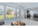 Bright sunroom features tiled floors, comfy seating, and access to backyard at 664 Linden Dr, Englewood, FL 34223