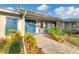 Front porch with blue door, stone walkway, and lush landscaping at 700 Valencia Rd, Venice, FL 34285