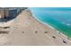 Sunny beach aerial view with clear turquoise water, buildings in the background and sandy shoreline at 840 The Esplanade N # 104, Venice, FL 34285