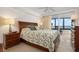 Bright main bedroom featuring large windows with ocean views, wood furniture, and a comfortable king bed at 840 The Esplanade N # 104, Venice, FL 34285