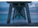View under the pier, highlighting the pier's structure with the water meeting the sand at 840 The Esplanade N # 104, Venice, FL 34285