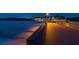 Illuminated wooden pier extends over the beach and into the ocean during the nighttime at 840 The Esplanade N # 104, Venice, FL 34285