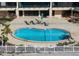 A kidney shaped pool with lounge chairs and a well maintained patio are featured at 840 The Esplanade N # 104, Venice, FL 34285