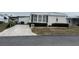 Single-wide manufactured home with carport and landscaped yard at 863 Baveno Dr, Venice, FL 34285