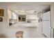 Kitchen with white cabinets, breakfast bar, and appliances at 958 Sunridge Dr # H3, Sarasota, FL 34234
