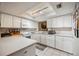 White kitchen with island, appliances, and view to dining area at 958 Sunridge Dr # H3, Sarasota, FL 34234