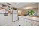 White kitchen cabinets and appliances, view to dining area at 958 Sunridge Dr # H3, Sarasota, FL 34234