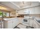 Open kitchen with white cabinets, island, and appliances at 958 Sunridge Dr # H3, Sarasota, FL 34234