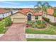 Single-story house with brick driveway and landscaping, near a lake at 9895 Wingood Dr, Venice, FL 34292