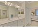 Elegant bathroom with double vanity, large mirror, and access to bedroom at 9895 Wingood Dr, Venice, FL 34292