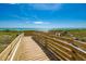 Wooden boardwalk leads to beach with stunning ocean views at 9895 Wingood Dr, Venice, FL 34292