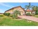 House exterior showcasing a tan elevation and landscaping at 9895 Wingood Dr, Venice, FL 34292