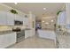 Modern kitchen with white cabinets, granite counters, and stainless steel appliances at 9895 Wingood Dr, Venice, FL 34292