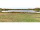 Community lake view with homes along the shoreline and grassy area at 9895 Wingood Dr, Venice, FL 34292