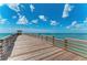 Long wooden pier extending over the ocean on a sunny day at 9895 Wingood Dr, Venice, FL 34292