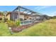Relaxing pool area with screened enclosure, lush landscaping, and patio furniture at 9895 Wingood Dr, Venice, FL 34292
