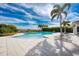 Community pool with lounge chairs and surrounding patio at 9895 Wingood Dr, Venice, FL 34292