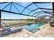 Screened pool and patio area with lounge chairs overlooking a lake at 9895 Wingood Dr, Venice, FL 34292