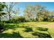 Spacious backyard with lush lawn, mature trees, and privacy at 107 Corte Del Rosa, Venice, FL 34285
