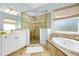 Bathroom with walk-in shower, soaking tub, and double vanity at 107 Corte Del Rosa, Venice, FL 34285