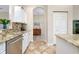 Kitchen with granite counters, stainless steel appliances, and hardwood floors at 107 Corte Del Rosa, Venice, FL 34285