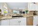 Kitchen features granite counters, stainless steel appliances, and a large sink at 107 Corte Del Rosa, Venice, FL 34285