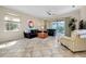 Bright living room featuring leather sofas, a coffee table, and sliding glass doors at 107 Corte Del Rosa, Venice, FL 34285