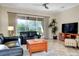 Living area with leather sofas, a wood coffee table, and a large TV at 107 Corte Del Rosa, Venice, FL 34285