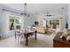 Open concept dining room featuring a rustic wooden table and light-colored chairs at 11053 Barnsley Dr, Venice, FL 34293