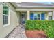 Front entry with blue shutters, glass door, and brick walkway at 12386 Sagewood Dr, Venice, FL 34293