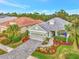 Single-story house with light green exterior, gray roof, and landscaped yard at 12386 Sagewood Dr, Venice, FL 34293