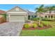 Single story home with light green exterior, gray roof, and landscaped yard at 12386 Sagewood Dr, Venice, FL 34293