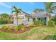 Single story home with light green exterior, gray roof, and landscaped yard at 12386 Sagewood Dr, Venice, FL 34293