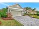 Attached garage with light green doors and stone accents at 12386 Sagewood Dr, Venice, FL 34293
