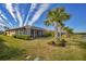 Beautiful backyard with pond view, lush lawn, and palm trees at 13836 Karina St, Venice, FL 34293