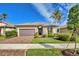 Single-story home with brown garage door, landscaping, and palm trees at 13836 Karina St, Venice, FL 34293