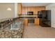 Kitchen features granite countertops, stainless steel sink, and ample wood cabinetry at 157 Tampa E Ave # 407, Venice, FL 34285