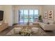 Bright living room with water views, featuring a comfy sectional sofa and access to a balcony at 157 Tampa E Ave # 407, Venice, FL 34285