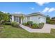Light teal house with a screened porch, two-car garage, and nicely landscaped yard at 1630 Monarch Dr, Venice, FL 34293