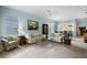 Spacious living room with light beige sofas and a view into the kitchen and sunroom at 1630 Monarch Dr, Venice, FL 34293