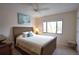 Bedroom with wicker bed frame, ceiling fan, and window with nature view at 1640 Stickney Point Rd # 202, Sarasota, FL 34231
