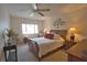 Spacious bedroom with a wooden sleigh bed, ceiling fan, and ample natural light at 1640 Stickney Point Rd # 202, Sarasota, FL 34231