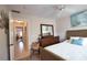 Bedroom with wicker bed frame, dresser and a view of hallway at 1640 Stickney Point Rd # 202, Sarasota, FL 34231