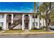 Two-story condo building with wood stairs and lush landscaping at 1640 Stickney Point Rd # 202, Sarasota, FL 34231