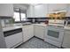 White kitchen with updated appliances and blue tile backsplash at 1640 Stickney Point Rd # 202, Sarasota, FL 34231
