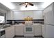 Bright kitchen with white cabinets, tile floors, and appliances at 1640 Stickney Point Rd # 202, Sarasota, FL 34231