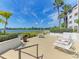 Waterfront patio with lounge chairs and tables at 1640 Stickney Point Rd # 202, Sarasota, FL 34231