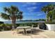 Outdoor patio with table, chairs, and grill overlooking water at 1640 Stickney Point Rd # 202, Sarasota, FL 34231