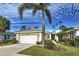 Single-story home with white garage door and palm tree in front at 1655 Lancashire Dr # 1655, Venice, FL 34293